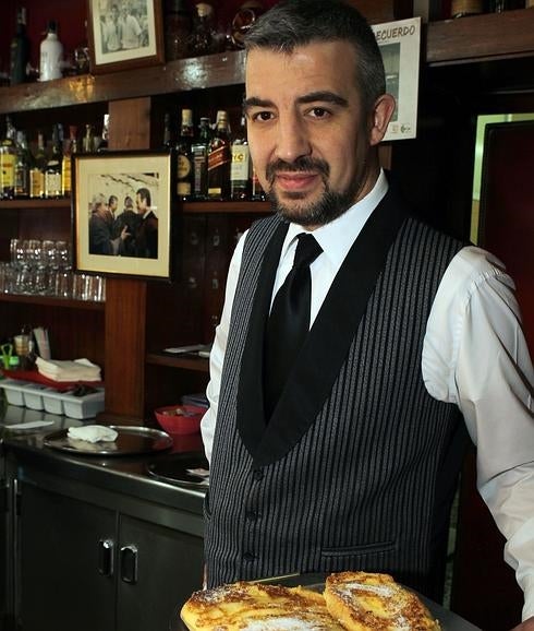 Paco Velasco, copropietario de La Tropical, posa con un plato de torrijas. 