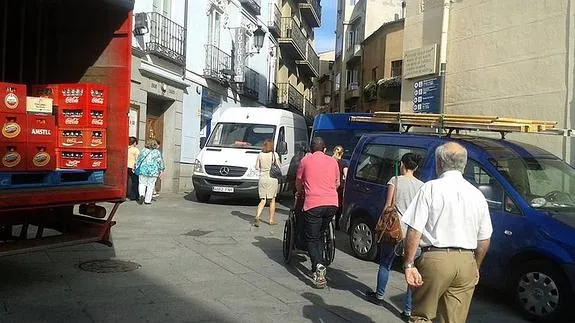 Peatones y vehículos de reparto en la Calle Real.