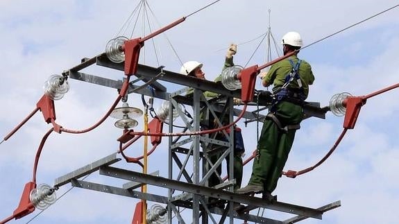Trabajadores de Iberdrola ponen los aislantes en una torre electrica para evitar la muerte de aves en Campo Azálvaro-Pinares de Peguerinos, Segovia. / EL NORTE 