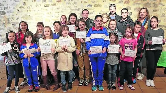 Los escolares premiados posan con sus diplomas, junto a concejales y colaboradores.