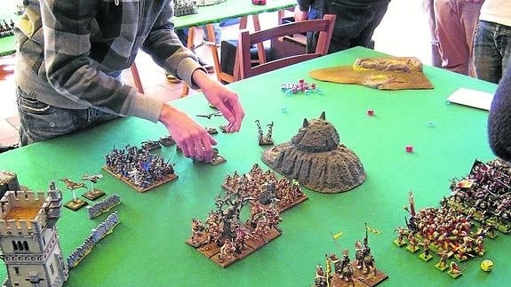 Miniaturas colocadas sobre un tablero para ser utilizadas en una batalla del torneo Warhammer.