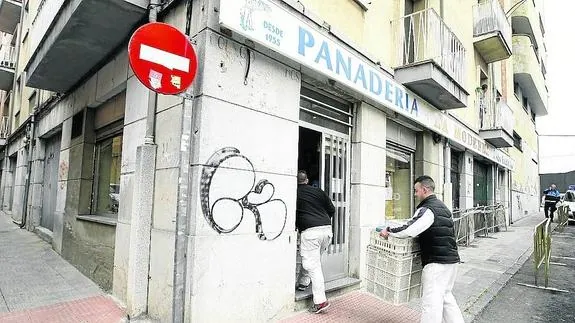 Dos empleados de Panadería La Moderna acceden al obrador situado en la calle Norte.