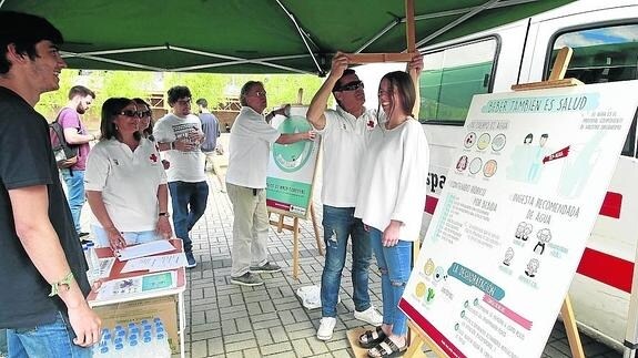 Un voluntario atiende a una joven en el Punto Saludable instalado por Cruz Roja en el Campus Unamuno.