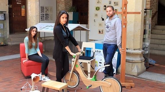 Una alumna y dos exalumos del centro muestran algunos de los diseños realizados. Antonio Tanarro