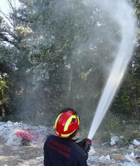Un bombero moja las pelusas de los chopos en el camino de Juana Jugan. 