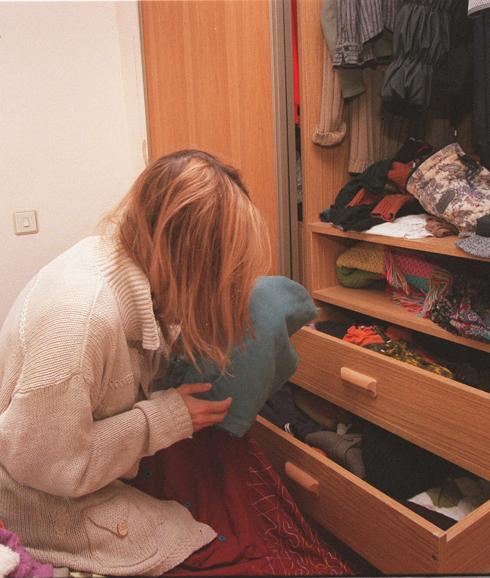 na mujer ordena la ropa de su armario.