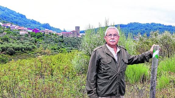 Rafael Rivero, alcalde de Herguijuela de la Sierra, y al fondo uno de los símbolos del municipio, la iglesia.