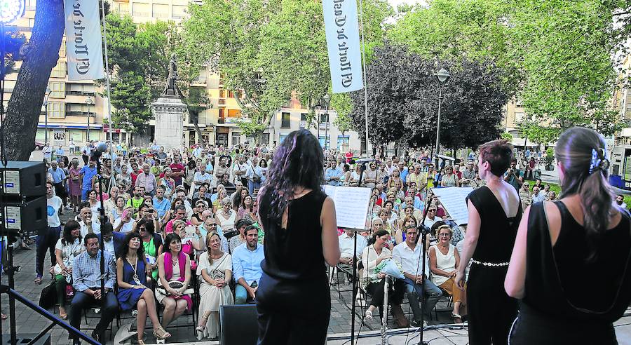Un momento del concierto del trío Rigoletto, con la estatua de Cervantes al fondo y la plaza de la Universidad repleta de Publico