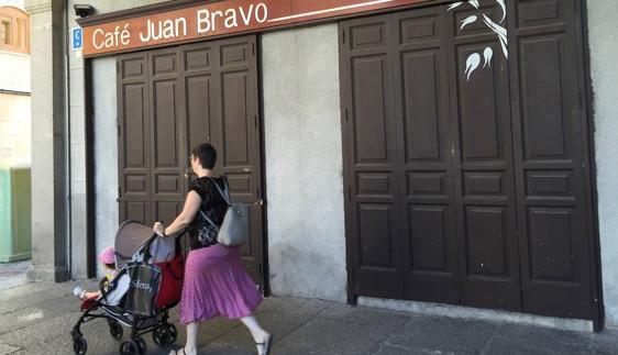 Una mujer pasea con el carrito del niño ante la fachada del café del teatro Juan Bravo, ahora cerrado 