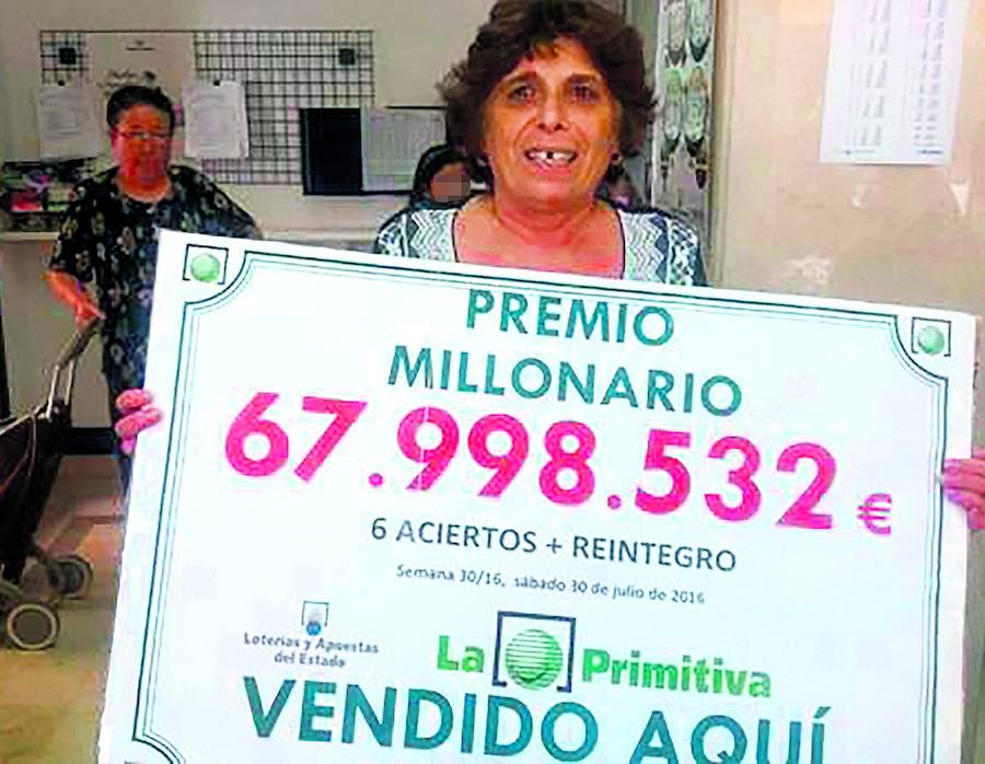 La afortunada muestra el cartel del premio, en la administración conquense de Quintanar del Rey. 
