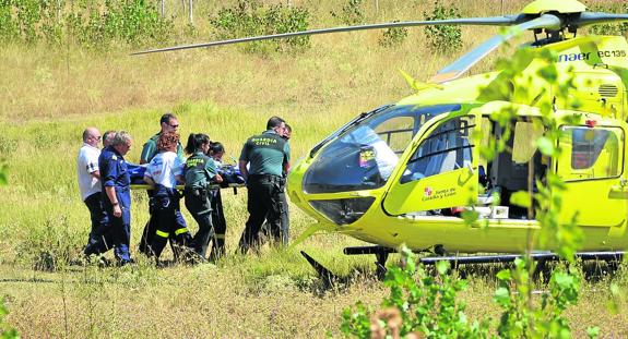 Personal sanitario y agentes de la Guardia Civil trasladan al niño hasta el helicóptero. 