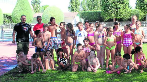 Los niños y sus familiares posan en las instalaciones de la piscina de Aguilafuente, donde se celebró el encuentro. 
