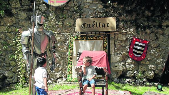 Dos niños observan una de las armaduras instaladas en el parque de la Huerta del Duque. 
