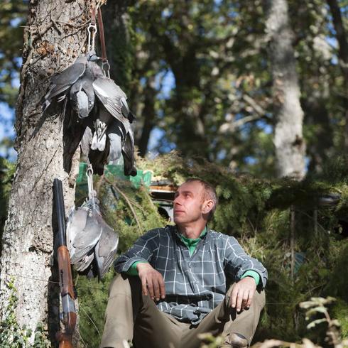 Un cazador descansa con las palomas alcanzadas