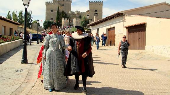 Sus Majestades, acompañados por el cortejo, desfilan hacia el pueblo desde el castillo.