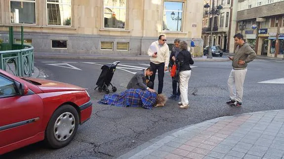 Unos viandantes atienden a la mujer.