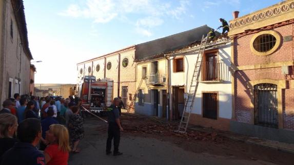 Labores de extinción en la casa de la víctima y en la colindante durante el incendio del sábado. 