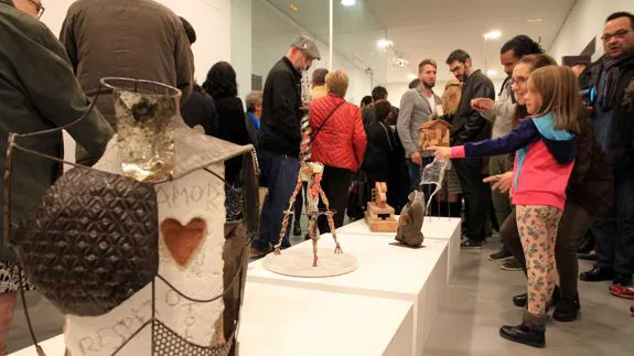 Visitantes de la exposición ‘Escombrarte’ observan algunas de las esculturas, ayer en el Palacio de Quintanar. Antonio Tanarro