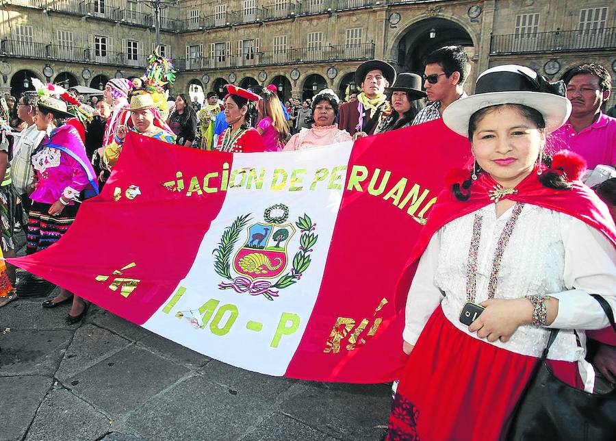 Peruanos residentes en Salamanca posan con indumentaria tradicional peruana y con la bandera de su país en la Plaza Mayor. 
