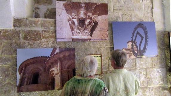 Dos visitantes observan las fotografías en el monasterio de San Zoilo.