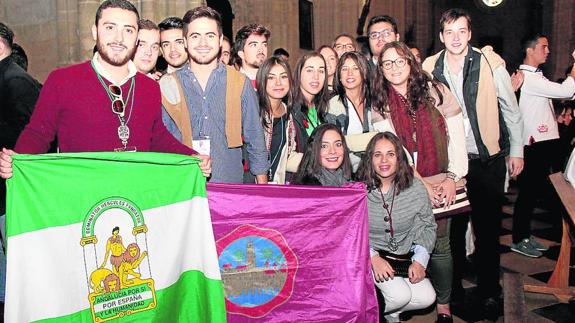 Jóvenes cofrades de Córdoba muestran la bandera de Andalucía y la de su ciudad. 