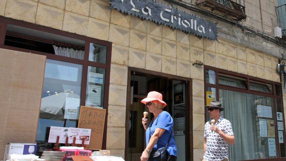 Dos personas, frente a la fachada del restaurante La Criolla.Tanarro