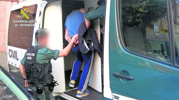 La Guardia Civil introduce a uno de los detenidos en un furgón. 