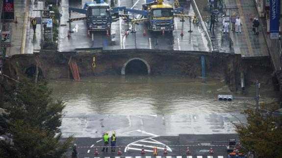 Un gran socavón corta una avenida en el centro de Fukuoka al suroeste de Japón. 