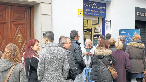 Personas hacen cola a las puertas de una administración de loteria de Segovia. De Torre