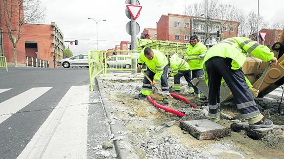 Varios operarios arreglan el pavimento urbano de una calle de la capital.