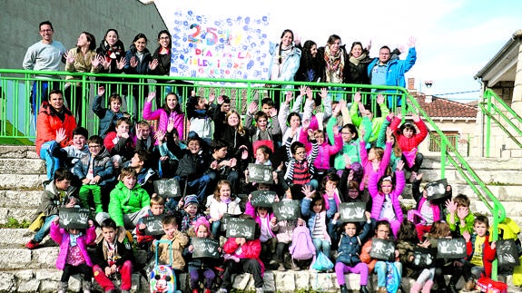 Los profesores y los niños del CRA El Olmar muestra un mural contra la violencia machista en el patio del colegio de Olombrada. El Norte