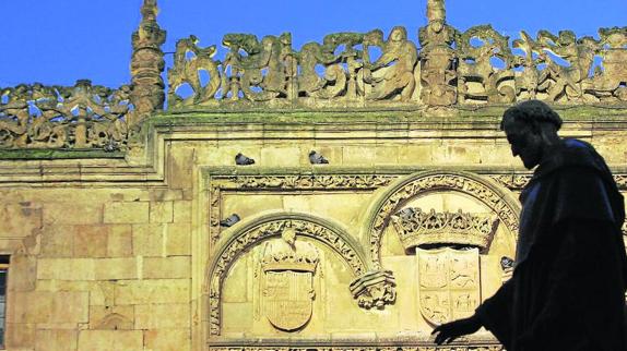 Perfil de la escultura de Fray Luis, con la fachada de la Universidad al fondo. 
