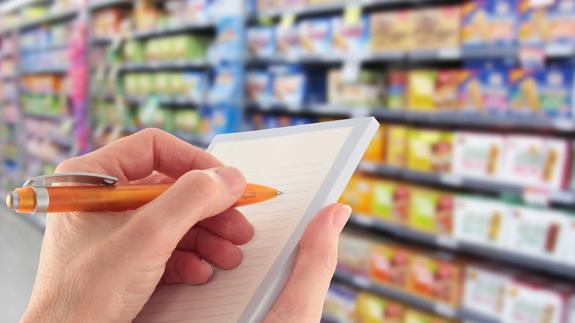 mujer hace la lista de la compra en un supermercado.
