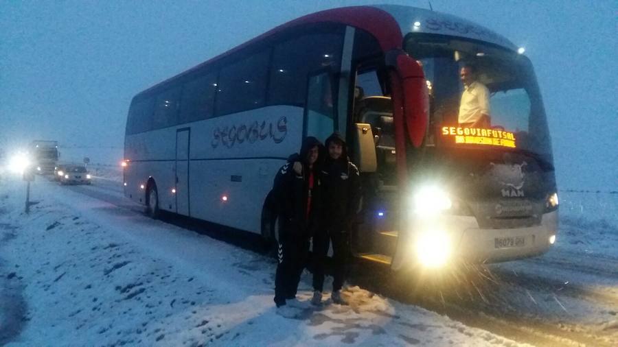 Juanfran y Álvaro, junto al autobús del equipo parado en la carretera.