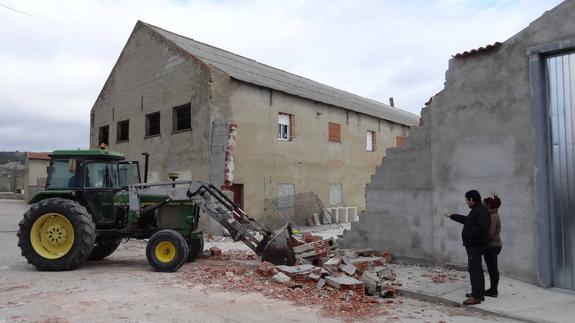 Un tractor retira los cascotes del boquete abierto por el camión al arrancar la puerta y derribar la pared.