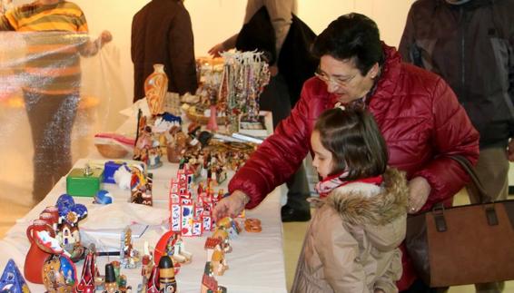 Una mujer y una niña observan algunas de las piezas.