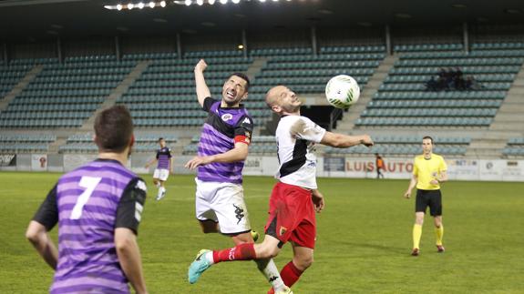 Pelayo salta a por el balón junto a un rival del Tudelano. 