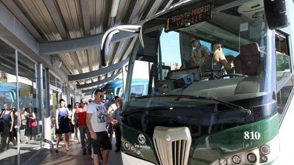 Viajeros se suben a un autobús que cubre la línea Segovia-Madrid. 