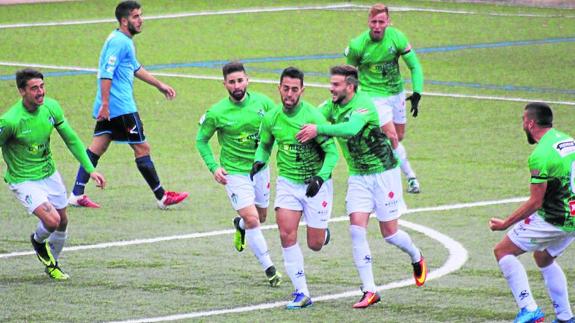 Los jugadores del CDGuijuelo felicitan al delantero Pino tras marcar uno de sus goles al Boiro.