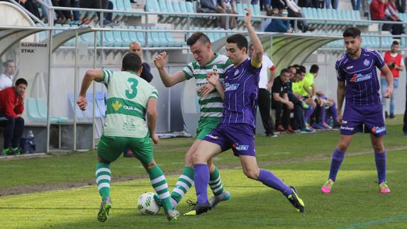 Javi Bueno, en el centro, lucha por un balón frente a un rival de La Virgen del Camino.