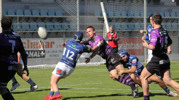 El jugador morado Paco da un pase a sus compañeros antes de ser placado por dos rivales pucelanos. 