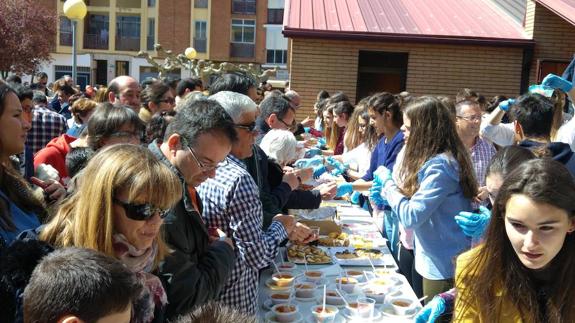 Los vecinos, junto a la barra de tapas solidarias. 