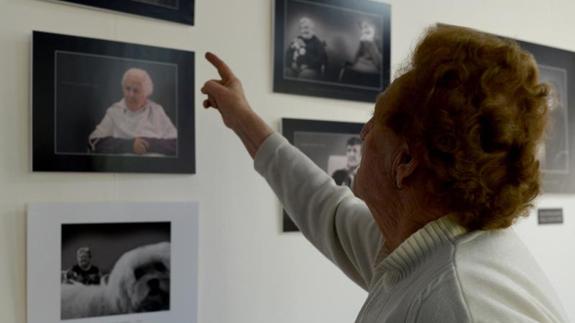 Una de las residentes del centro de Tercera Actividad observa las fotografías que componen la exposición. EL NORTE