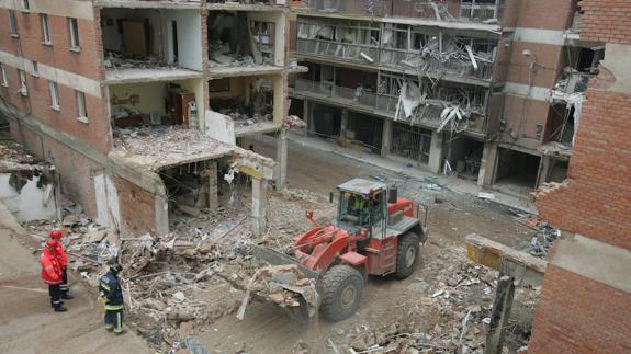 Una excavadora recoge restos de los escombros del edificio derrumbado tras la explosión de gas de Gaspar Arroyo