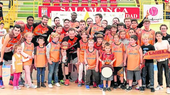 La plantilla del Aquimisa Carbajosa posa con un grupo de jóvenes canteranos del club para celebrar el ascenso a la Liga EBA