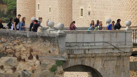 Grupos de visitantes en el puente de entrada del Alcázar. 