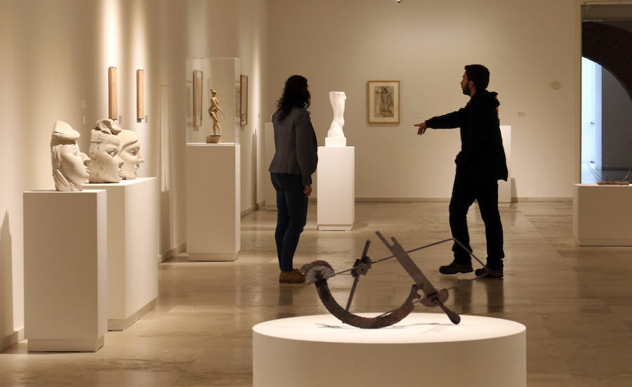 Dos visitantes contemplan piezas de la muestra en la sala 1 del Patio Herreriano. 