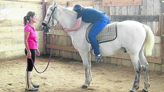 La terapeuta de caballo guiando a Laura en una de sus sesiones de equinoterapia, una terapia financiada por el BBVA durante todo 2017. 