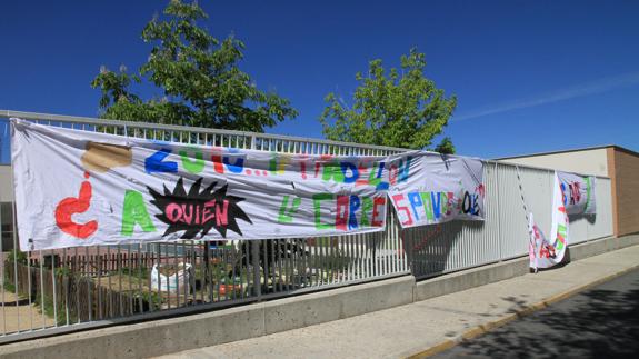 Sábanas con lemas reivindicativos colgadas en las verjas del colegio Peñascal. 
