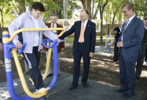 Autoridades y directivos contemplan cómo una vecina estrena uno de los aparatos del parque. / P. P. S.